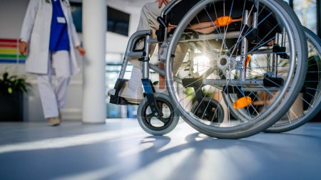 Foto de Primer plano de la silla de ruedas con la mujer mayor en un pasillo del hospital. - Imagen libre de derechos
