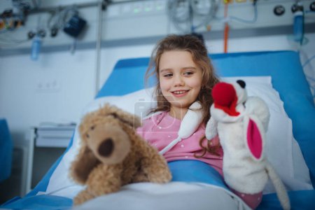 Téléchargez les photos : Portrait of little girl in a hospital room with her toys. - en image libre de droit