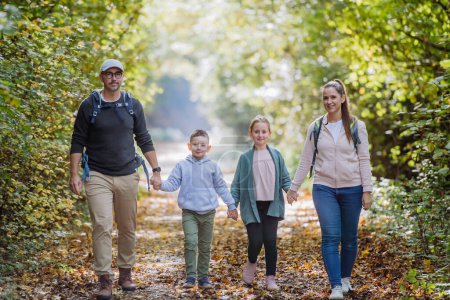 Foto de Happy family with kids walking in a forest. - Imagen libre de derechos