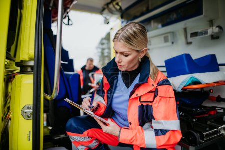 Photo for Young rescuer doctor checking equipment in an ambulance car. - Royalty Free Image