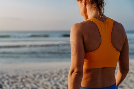 Photo for Rear view of young sportive woman at the beach. - Royalty Free Image