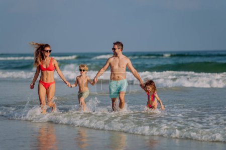 Foto de Familia feliz con niños pequeños disfrutando del tiempo en el mar en un país exótico. - Imagen libre de derechos