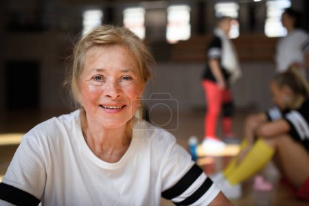 Téléchargez les photos : Happy senior woman stretching before basketball match in a gym. - en image libre de droit