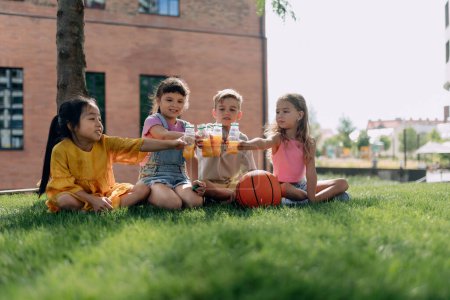 Photo for Happy kids playing and talking together in s city park, during summer day. - Royalty Free Image