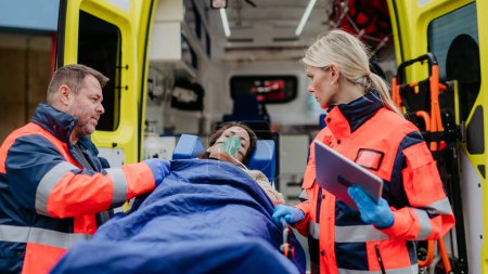 Téléchargez les photos : Rescuers taking care of a patient, preparing her for transport. - en image libre de droit