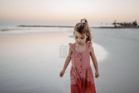 Téléchargez les photos : Little girl walking on the beach, enjoying summer exotic vacation. - en image libre de droit