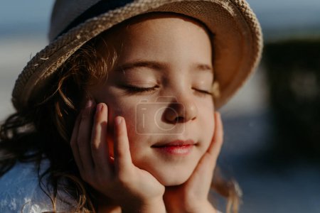 Téléchargez les photos : Portrait of little girl with closed eyes, at ocean. - en image libre de droit