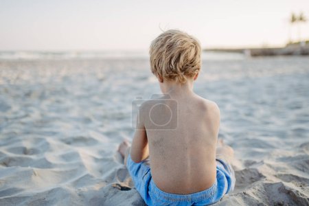Téléchargez les photos : Little boy playing on a beach, rear view. - en image libre de droit