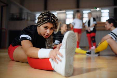 Photo for Group of multigenerational women, sports team players in gym stretching, warming up before match. - Royalty Free Image