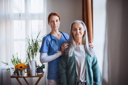 Téléchargez les photos : Portrait of senior caregiver and senior woman in her home. - en image libre de droit