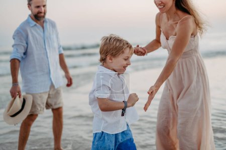 Téléchargez les photos : Famille heureuse avec petit fils profitant du temps à la mer dans un pays exotique. - en image libre de droit