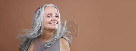Téléchargez les photos : Portrait of smiling senior woman in a studio. - en image libre de droit