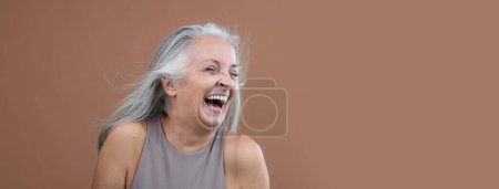 Téléchargez les photos : Portrait of smiling senior woman in a studio. - en image libre de droit