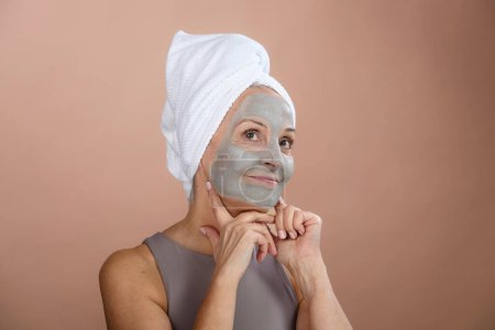 Téléchargez les photos : Portrait of excited senior woman with a face-mask, selfcare and skin routine concept. - en image libre de droit