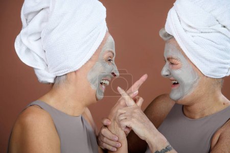 Foto de Portrait of happy senior friends with a face-mask, selfcare and skin routine concept. - Imagen libre de derechos