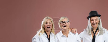 Téléchargez les photos : Portrait of three happy senior friends in a studio. - en image libre de droit