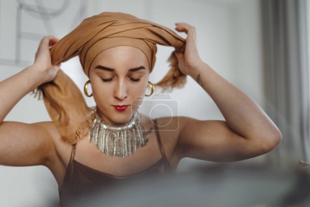 Foto de La rutina de belleza de una mujer joven con cáncer, conseguir bufanda. - Imagen libre de derechos