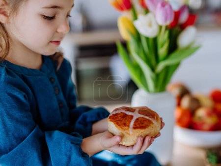 Téléchargez les photos : Little girl holding an easter pastries, celebrating easter and spring. - en image libre de droit