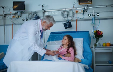 Photo for Doctor examining a little girl with broken arm. - Royalty Free Image