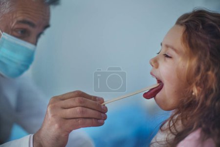 Photo for Close-up of examining little girls throat in a hospital. - Royalty Free Image