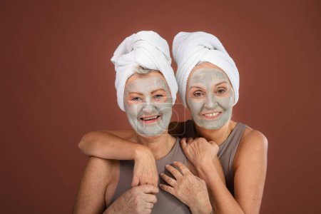 Téléchargez les photos : Portrait of happy senior friends with a face-mask, selfcare and skin routine concept. - en image libre de droit