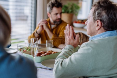 Photo for Close-up of family praying before Easter dinner. - Royalty Free Image