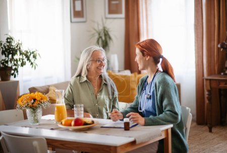 Photo for Nurse cosulting with senior woman her health condition at her home. - Royalty Free Image