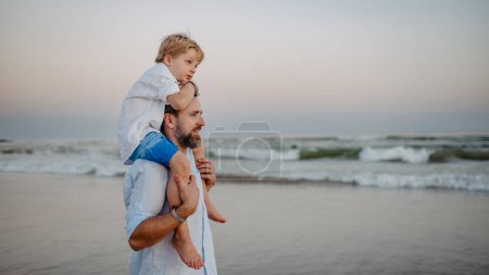 Foto de Padre con su hijo disfrutando juntos del tiempo en el mar. - Imagen libre de derechos
