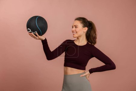 Photo for Portrait of young woman in sportive clothes with a medicimbal. - Royalty Free Image