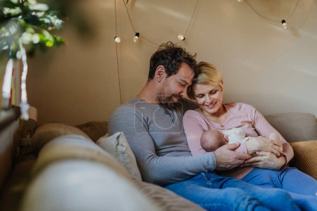 Photo for Parents holding their newborn son in their home. - Royalty Free Image
