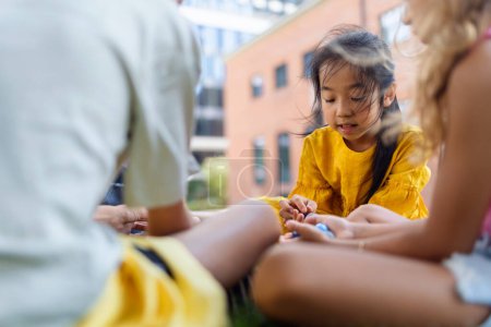 Photo for Happy kids playing and talking together in s city park, during summer day. - Royalty Free Image