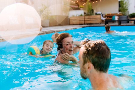 Téléchargez les photos : A multi generation family having fun and enjoying swimming in backyard pool. - en image libre de droit
