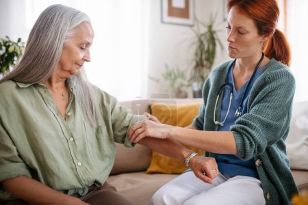 Téléchargez les photos : Nurse cosulting with senior woman her health condition at her home. - en image libre de droit