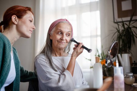 Téléchargez les photos : Femme âgée se maquiller à la maison. - en image libre de droit
