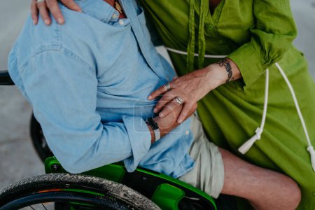 Photo for Close-up of senior man on wheelchair enjoying together time with his wife at the sea. - Royalty Free Image