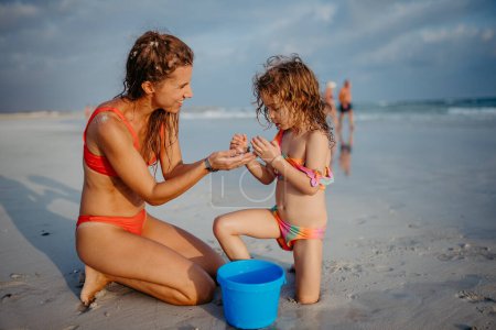 Foto de Madre con su hijita disfrutando del tiempo en el mar. - Imagen libre de derechos