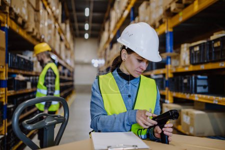 Photo for Warehouse female worker checking up stuff in warehouse. - Royalty Free Image