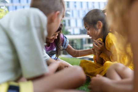 Foto de Happy kids playing and talking together in s city park, during summer day. - Imagen libre de derechos