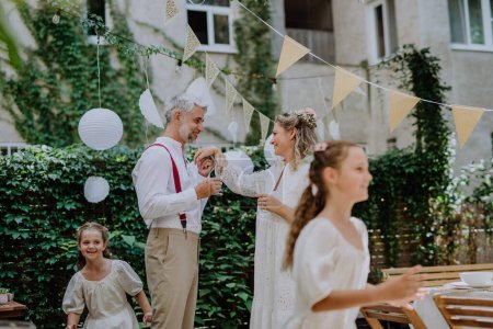 Téléchargez les photos : A mature bride and groom having a romantic moment at wedding reception outside in the backyard. - en image libre de droit
