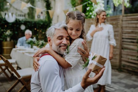 Foto de A mature father groom receiving gift from his daughter at wedding reception outside in the backyard. - Imagen libre de derechos