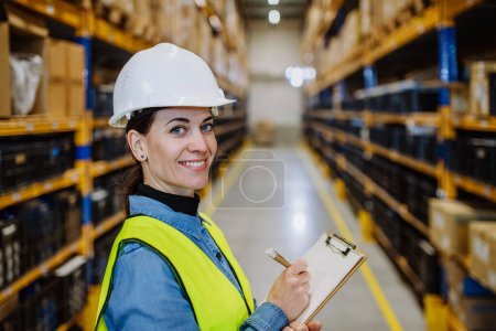 Foto de Warehouse female worker checking up stuff in warehouse. - Imagen libre de derechos