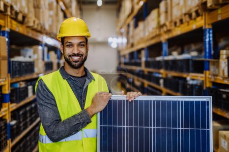Téléchargez les photos : Portrait of warehouse worker with a solar panel. - en image libre de droit