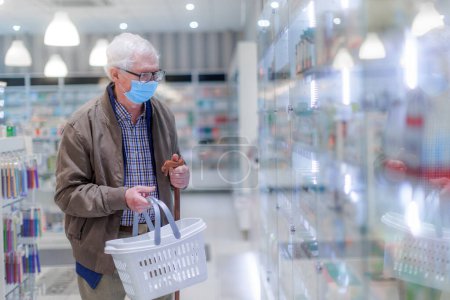 Téléchargez les photos : Homme âgé qui choisit des médicaments dans un magasin de pharmacie. - en image libre de droit