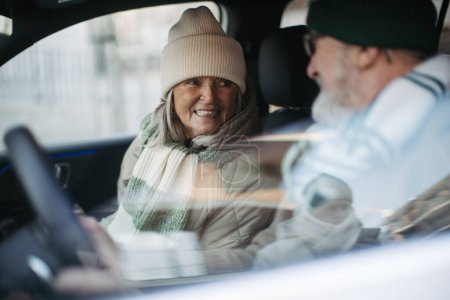 Téléchargez les photos : Couple âgé assis dans la voiture électrique. - en image libre de droit