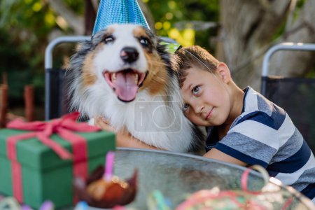 Foto de LIttle chico y su perro en la fiesta de cumpleaños celebración. - Imagen libre de derechos