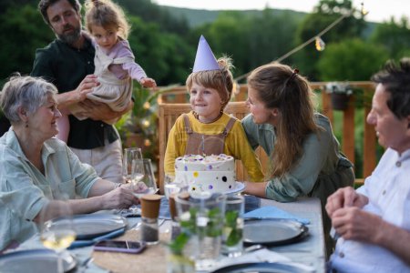 Foto de Una familia de varias generaciones celebrando cumpleaños y tienen fiesta de jardín al aire libre en el patio trasero en el patio. - Imagen libre de derechos