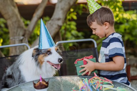 Photo for LIttle boy and his dog at birthday party celebration. - Royalty Free Image