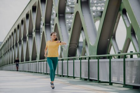 Téléchargez les photos : Jeune femme jogging à un pont de la ville, mode de vie sain et concept sportif. - en image libre de droit
