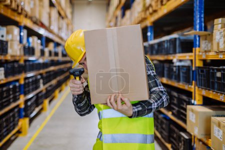 Photo for Warehouse worker stocking goods in warehouse. - Royalty Free Image