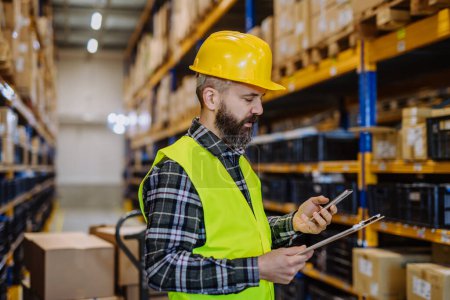 Photo for Warehouse worker checking up stuff in warehouse. - Royalty Free Image